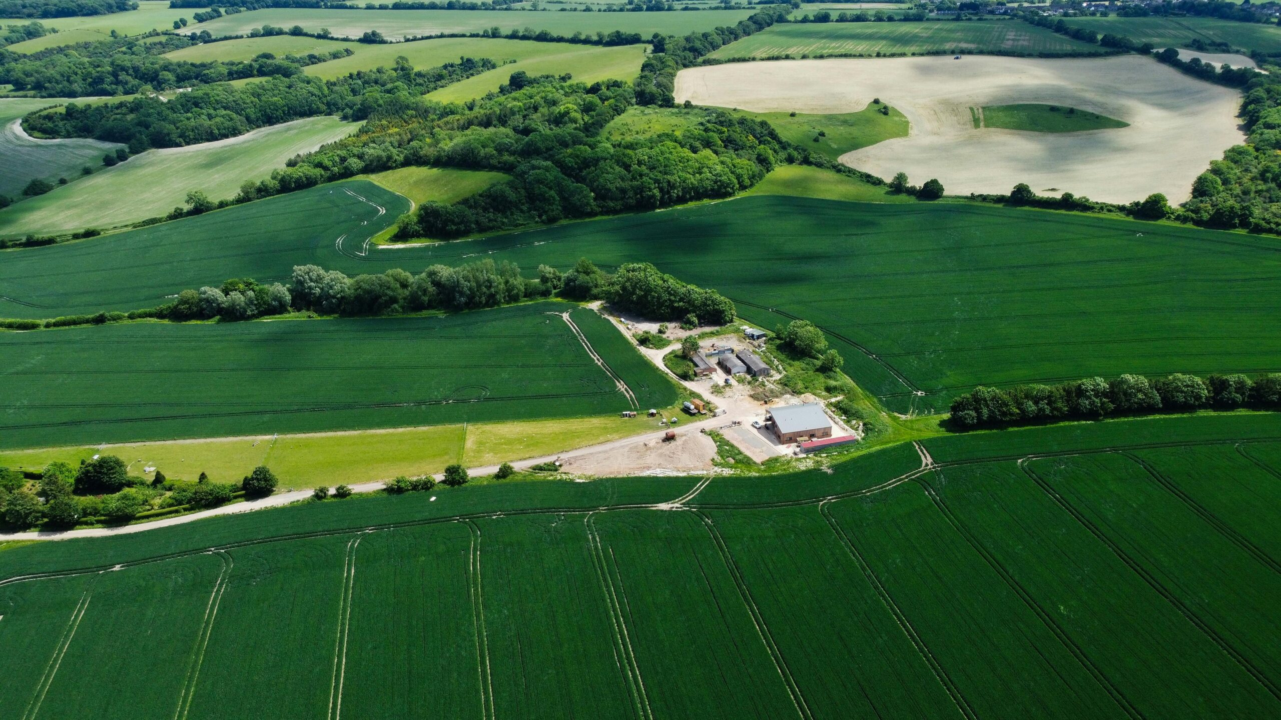 Projects Aerial photo capturing lush green fields and farmland in Harlington, England.
